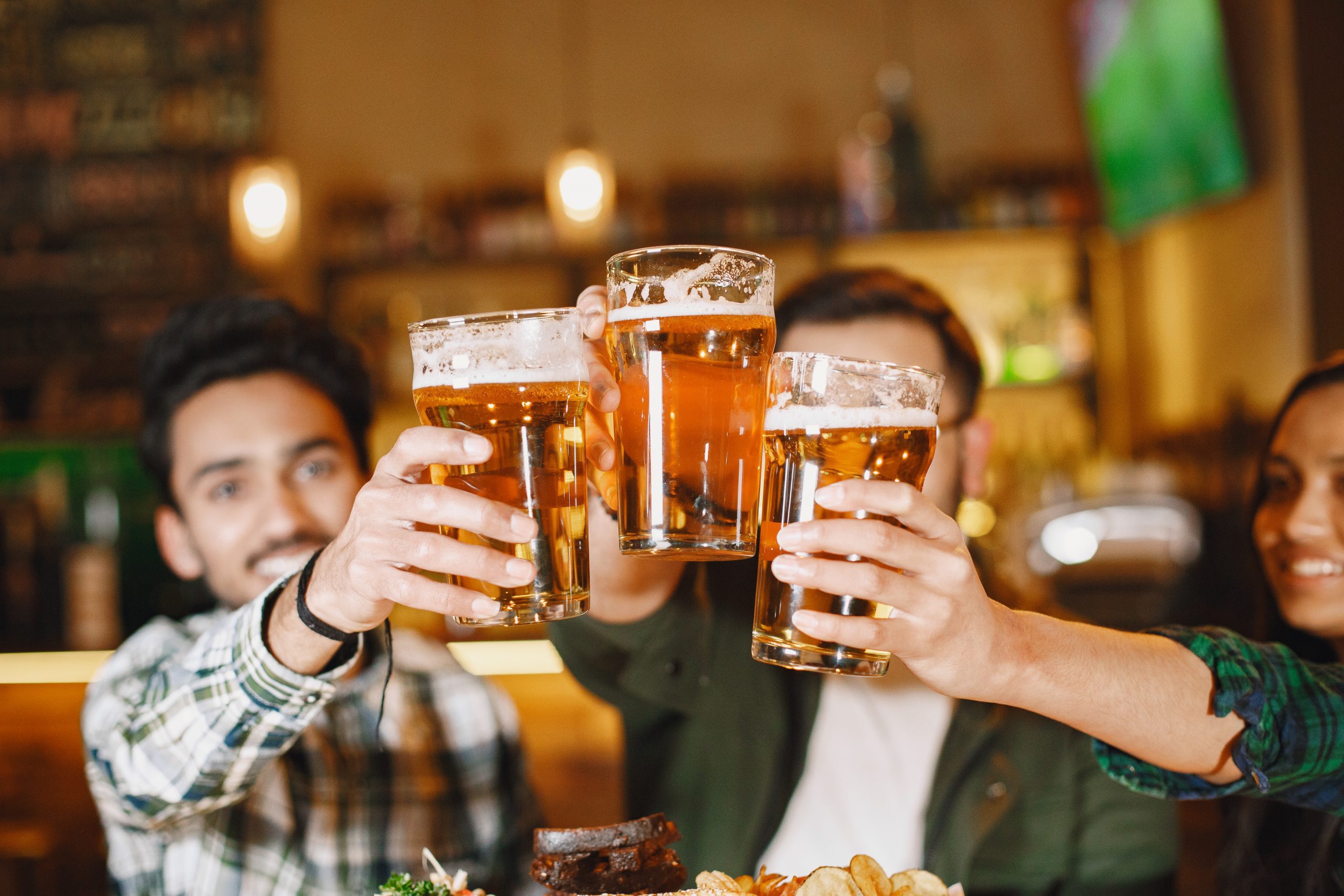 Indian friends celebrating in a pub with beer